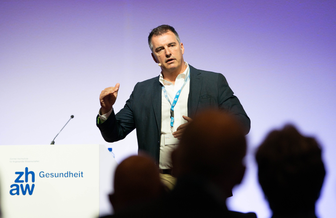 Alex Nelles delivering a thought-provoking speech on digital healthcare transformation at the ZHAW Digital Health Lab Day 2022, recognized as a thought leader in digital transformation across multiple industries including telecommunications, retail, and healthcare.